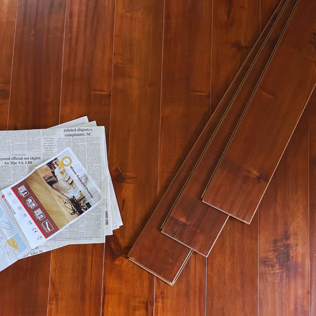 Milano wooden laminate flooring planks on polished brown floor with brochure